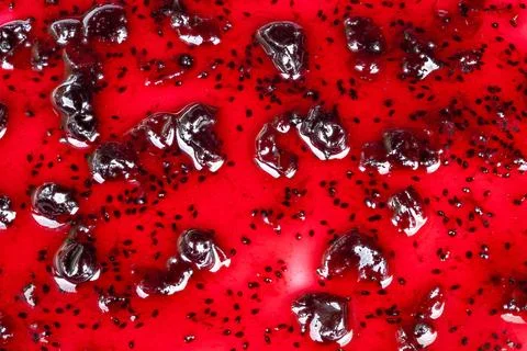 Bright macro image of glossy berry jam highlighting texture and shine. High cont 写真素材