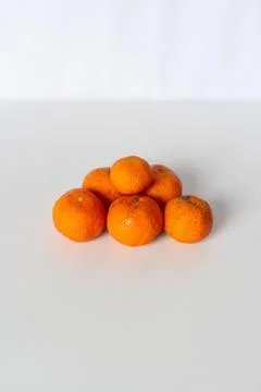 Bright mandarin oranges in a pile on a solid surface, healthy fruit Foto stock