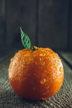 Bright mandarin with small green leaf Stock Photos