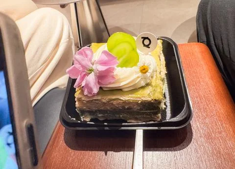 A bright mango cheesecake slice served on a white plate Stock Photos
