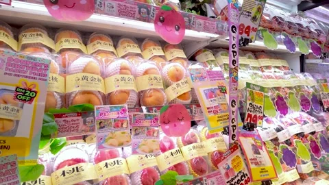 Bright market display of fresh packaged peaches with cute pink mascots Vidéo 318399883