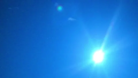 Bright Midday Sun with Powerful Rays and Lens Flare in Clear Blue Sky Video stock 347145812