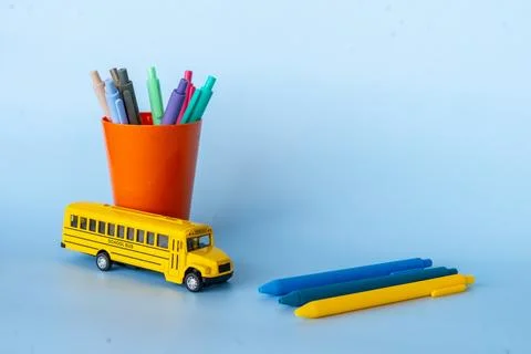 Bright minimal composition with yellow school bus orange pen holder and col.. Stock Photos