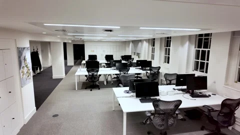 Bright, minimal office environment with desks, chairs, and computer monitors in Video stock 325838864