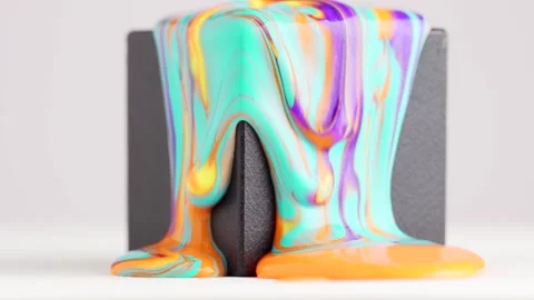 Bright mixed paint runs down the black cube. Orange and blue mixed liquid d.. Stock Footage 244705110