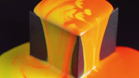 Bright mixed paint runs down the black cube. Orange and yellow mixed liquid.. Stock Footage 245144840