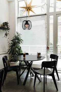Bright modern cafe interior featuring an iced coffee on a round table by th.. Stock Photos