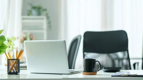 Bright modern workplace with laptop computer and office supplies. Stock Photos