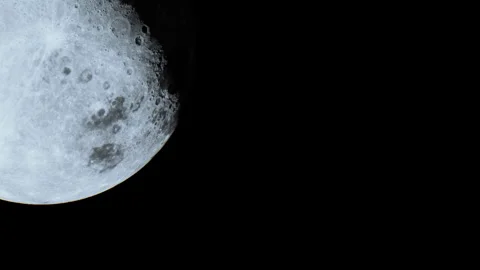 Bright moon over dark sky shows surface details at night Stock Footage 345054426
