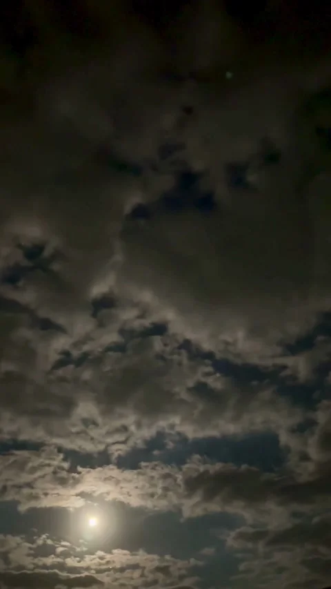Bright moon shines through moving clouds in night sky Stock-Footage 331982256