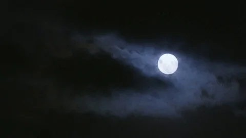 Bright moon shining through clouds on dark night Stock Footage 74062538
