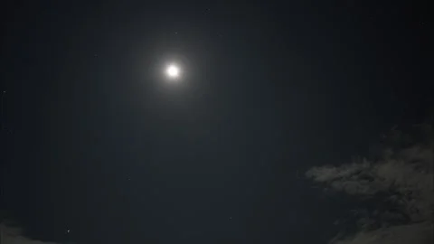Bright moon shining through moving clouds at night 库存影片 325024773