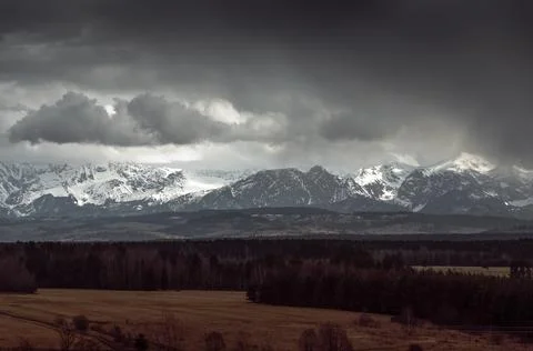 Bright mountains surrounded by dark clouds and impending rain. Stock Photos