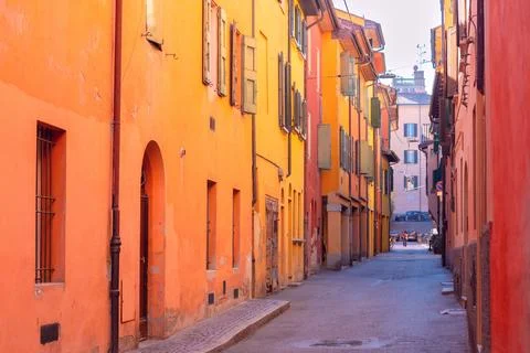 Bright multi-colored facades of old houses on a narrow street in Bologna. Stock Photos
