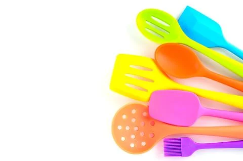 Bright multi colored kitchen utensils on white background with copy space Stock Photos