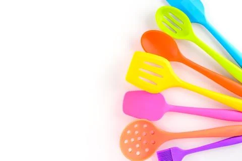 Bright multi colored kitchen utensils on white background with copy space Stock Photos