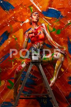 Bright multi-colored paint on the body of a young beautiful woman. Carnival Stock Photos