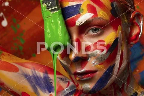 Bright multi-colored paint on the body of a young beautiful woman. Carnival Stock Photos