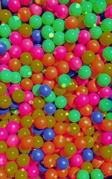 Bright multicolor plastic balls fill a children's play pit creating a fun a.. Stock Photos