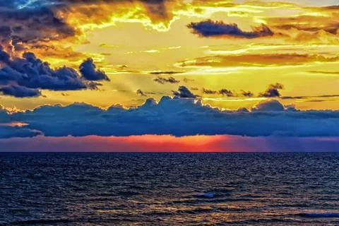 Bright multicolored evening sky after sunset over the sea Stock Photos