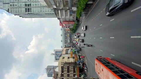 Bright multicolored taxis and regular buses travel along a street surrounded Stock Footage 157400749