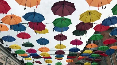 Bright multicolored umbrellas hanging in the sky above the street. The sky above Stock Footage 135406984