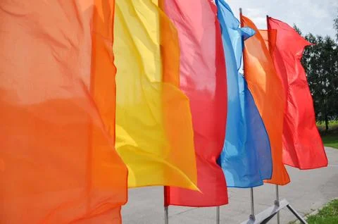 Bright multicolored vertical flags on flagpoles Stock Photos