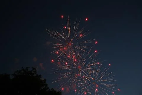 Bright multiple fireworks bursting in the dark night sky Stock Photos