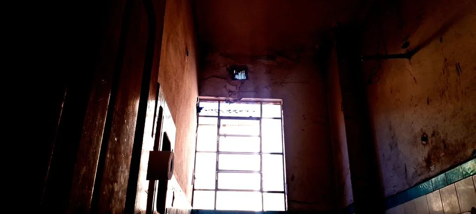 Bright natural light streaming through a dusty old iron window frame Stock Photos