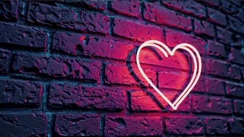 Bright neon heart glowing on a rustic brick wall in an urban setting at night Stock Footage 297317166