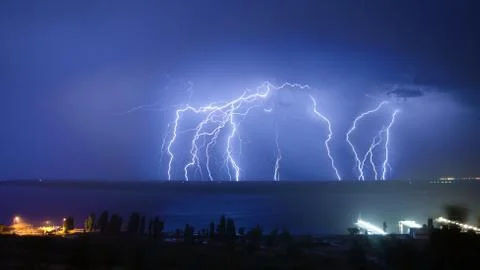 Bright night flash of lightning over the river Stock Photos