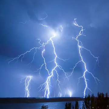 Bright night flash of lightning over the river Stock Photos