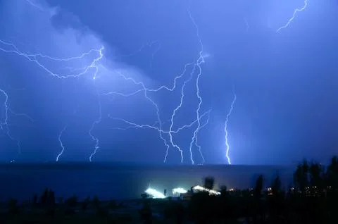 Bright night flash of lightning over the river Stock Photos