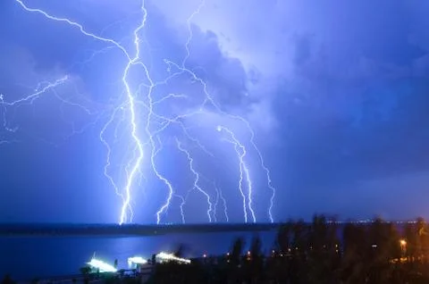 Bright night flash of lightning over the river Stock Photos