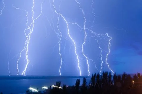 Bright night flash of lightning over the river Stock Photos