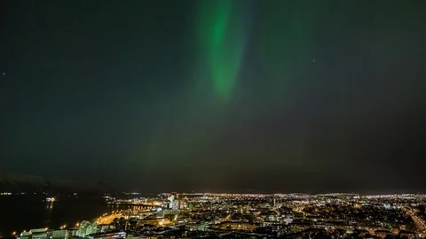 Bright northern light moving over the cityscape at night Video stock 73011364