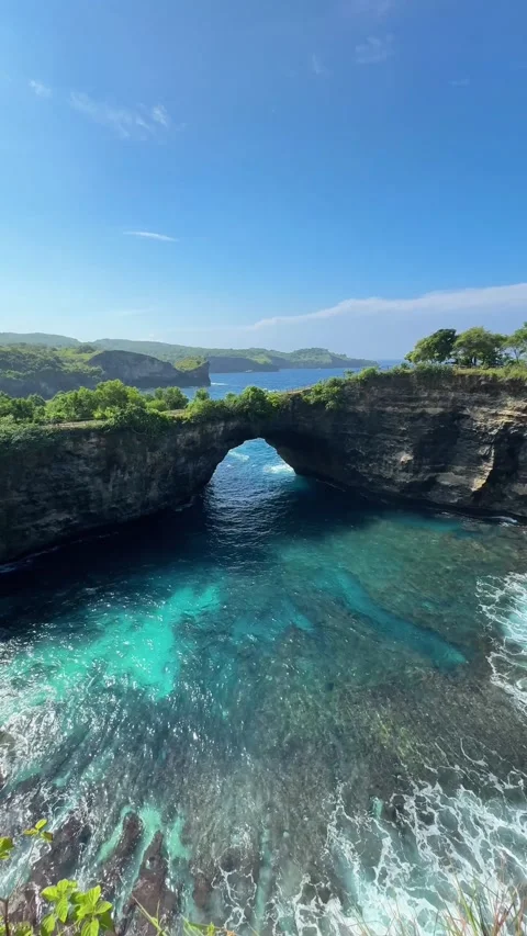 Bright ocean scenery, azure waters flowing under rocky arch with lively seaside Stock Footage 324807413