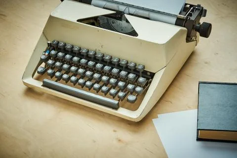 Bright old typewriter with gray keys and a book Foto stock
