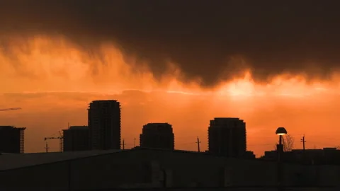 Bright orange and red sunset with dark clouds in sky Stock Footage 154205249
