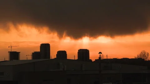 Bright orange and red sunset with dark clouds in sky 動画素材 154205915