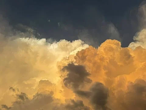 Bright orange and yellow clouds in a blue sky Stock Photos