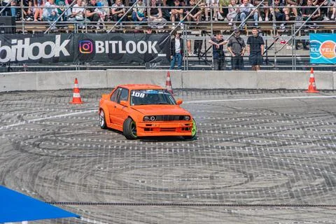 Bright orange BMW E30 M3 at a car racing event on an outdoor tarmac track, .. Foto stock