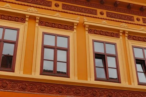 Bright Orange Building with Decorative Window Frame Details and a Vibrant Stock Photos