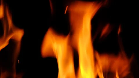 Bright orange flames dancing in the dark. Close-up view of fire creating Stock Footage 311051684