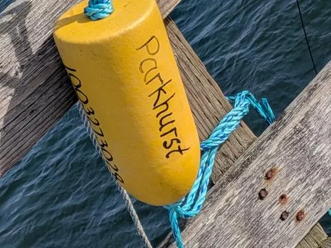 Bright orange floating device marked “Parkhurst” rests Фото