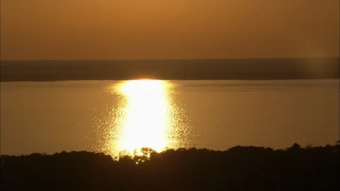 Bright orange light falling on the ocean at sunset, Sunset Over Roanoke Island Stock Footage 109139728