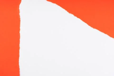Bright orange paper with a large torn hole revealing a clean white surface .. Фото