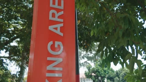 A bright orange pillar sign indicating a smoking area standing outdoors Video stock 343413786