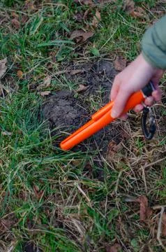 Bright orange pinpointer metal detector held in hand Foto stock