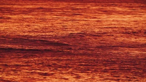 Bright orange, red pacific ocean from reflection of gorgeous Maui Hawaii sunset. Stock Footage 134846496
